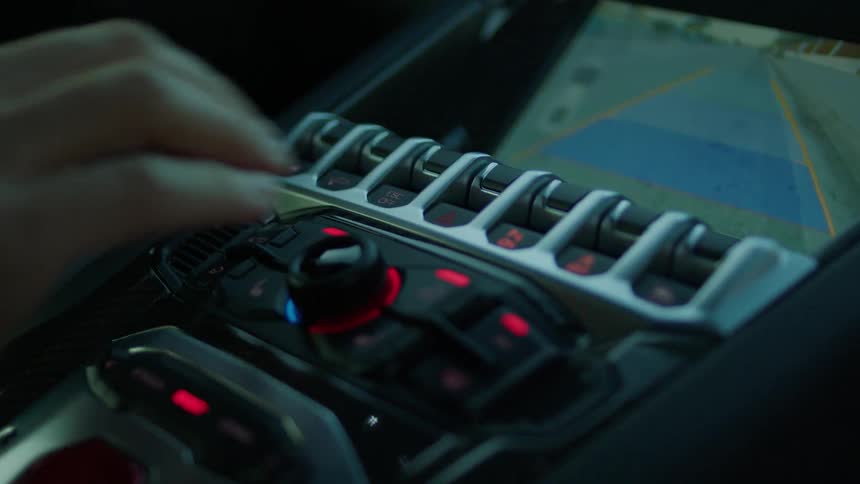 A person adjusts knobs on the dash of a car
