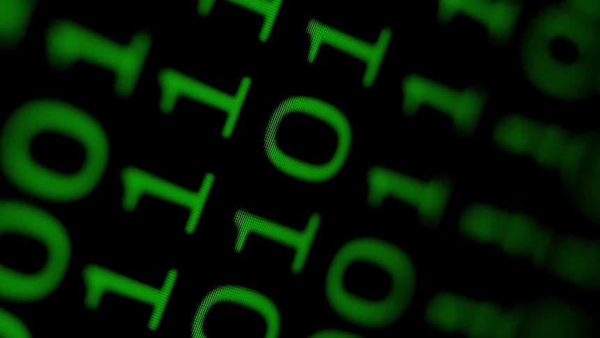 Binary code is displayed on a screen