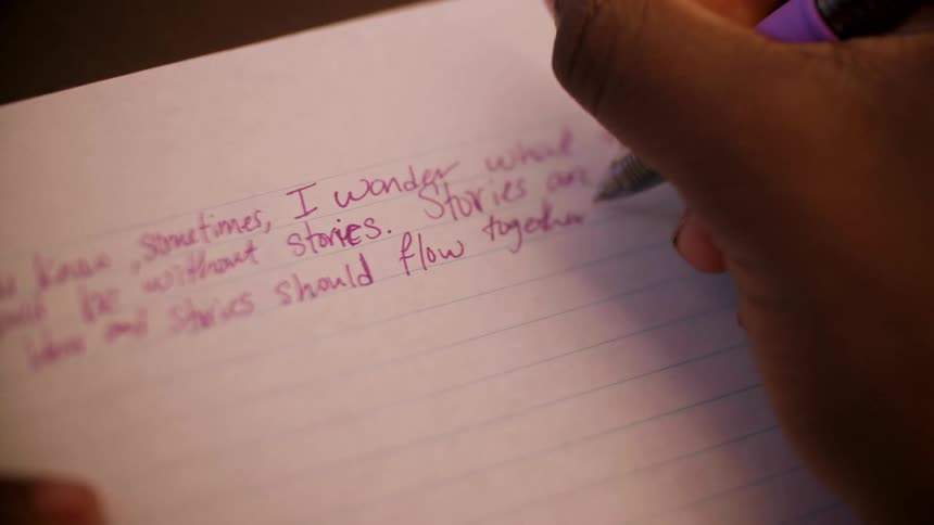 A young girl writes in a notebook