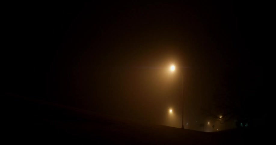 The dark field ahead has a tall lamp lighting it slightly