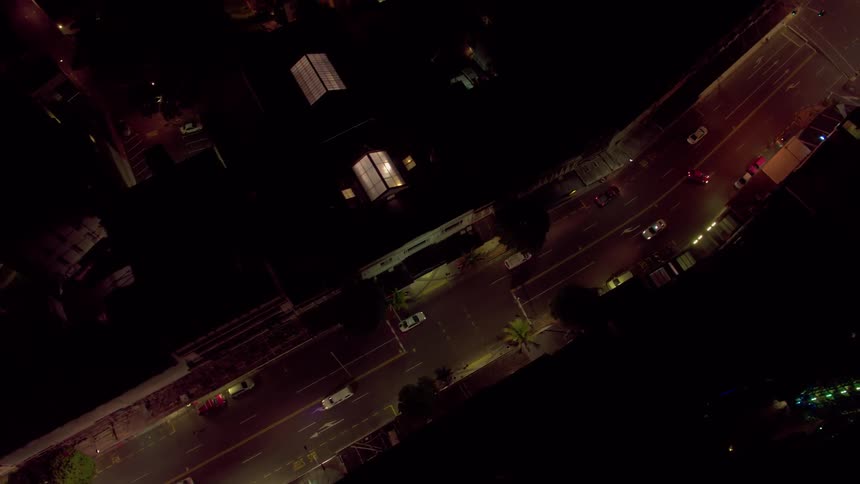 Vehicles travel on a city road at night