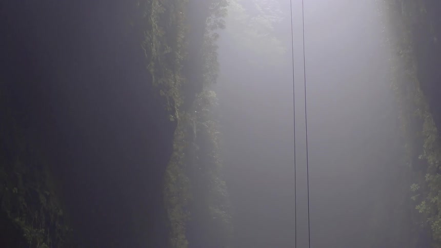 Two ropes are dangling next to a very large cliff