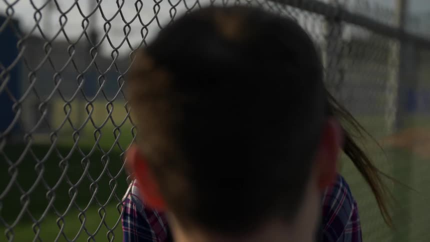 A young man and woman talk outside of a fence