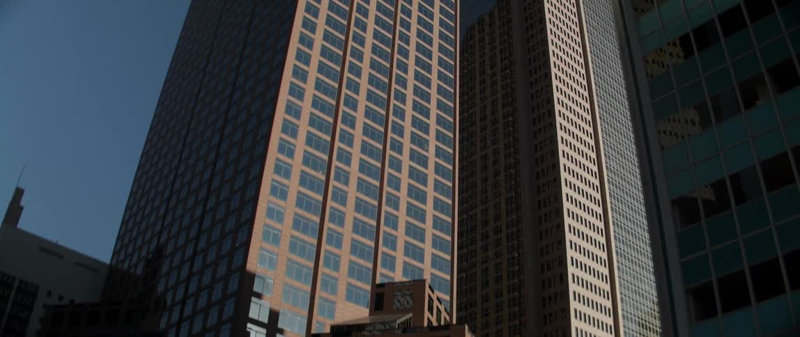Sun shining on city skyscrapers standing side by side