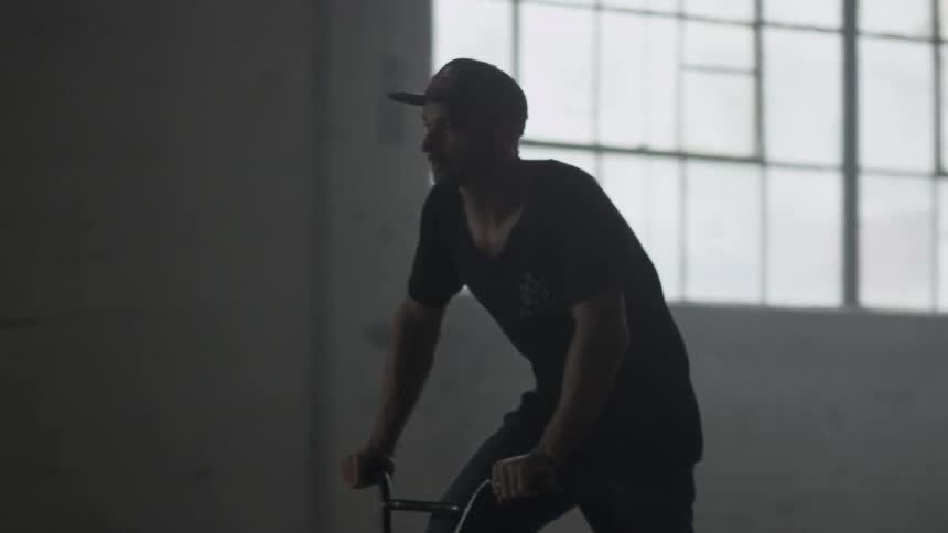A man is riding his bike in a warehouse
