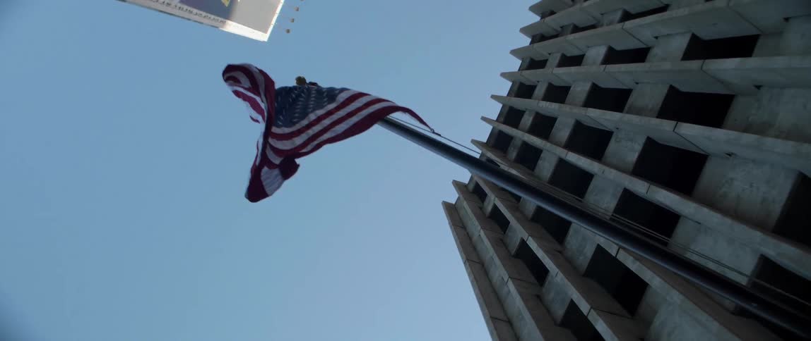 The flag on the side of the building blows in the wind