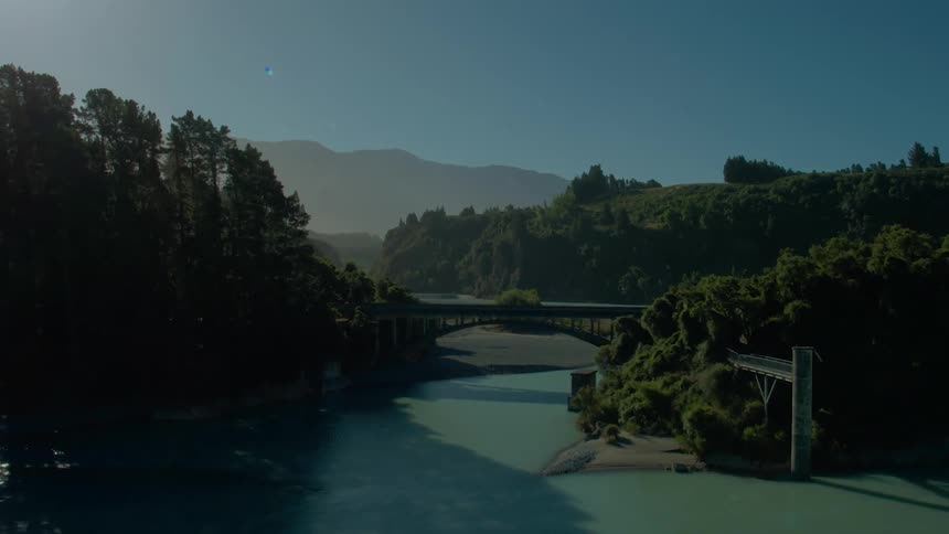 Glistening blue water flows in a river near a bridge