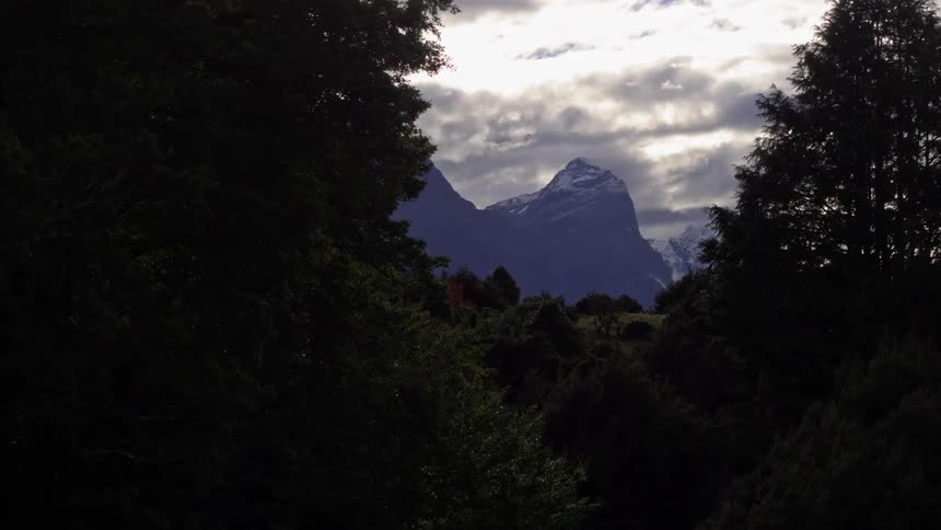 Rising up from an old house to see the steep mountain peaks beyond the trees