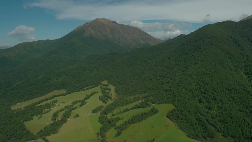 Mountains are covered with green shrubs and trees