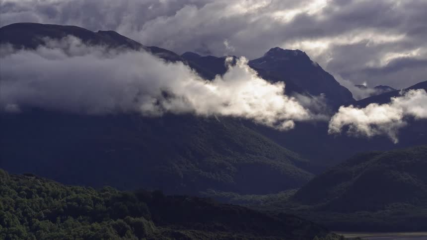 The clouds roll over the mountain top ahead
