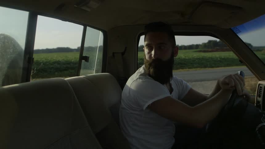 A man is driving his pickup truck on a cloudy day