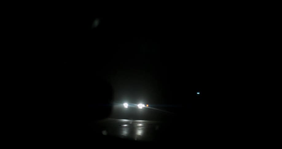 A vehicle passes on a road at night