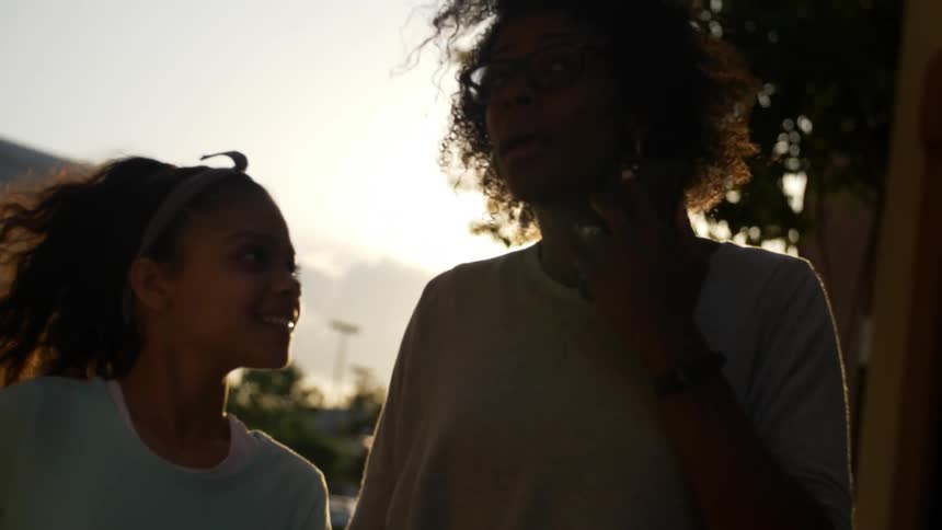 Girl and mother hold hands and go to play soccer