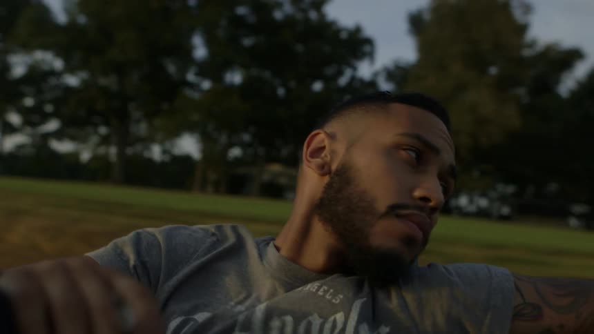 Man rides in the back of a truck smoking a cigarette