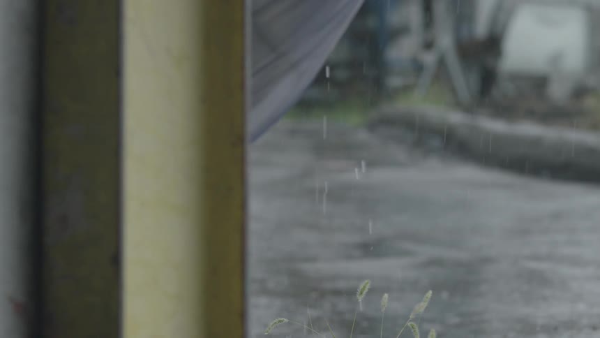 Rain is being filmed falling on an empty street