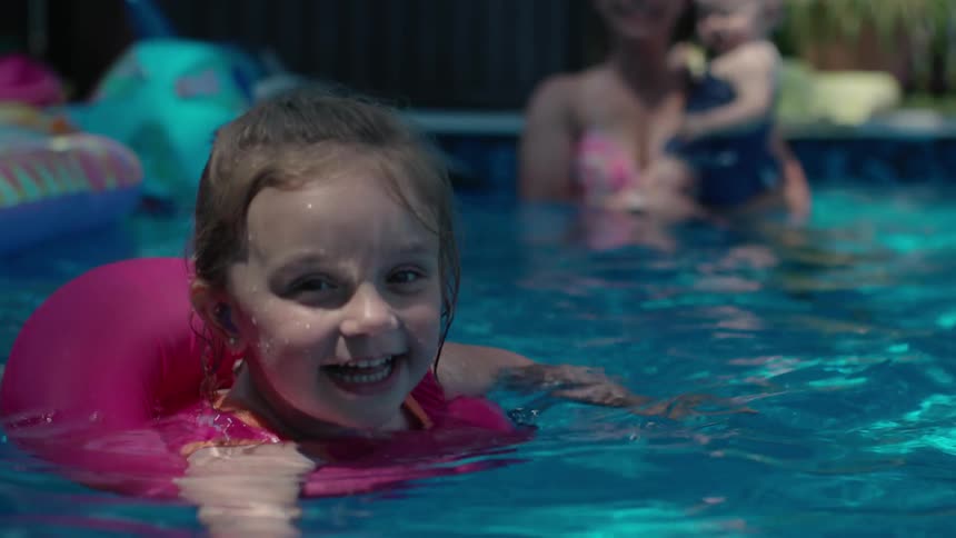 A young child is floating in a swimming pool