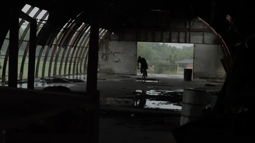 A man rides his bike through a warehouse