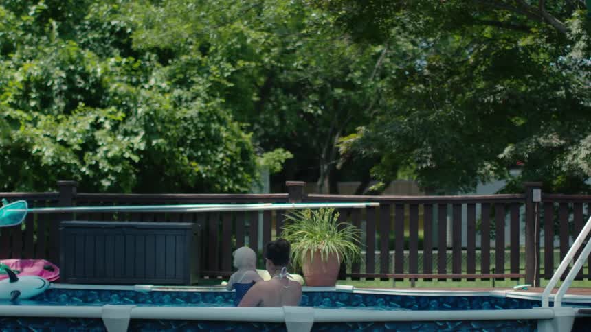 A woman and children are playing in the pool