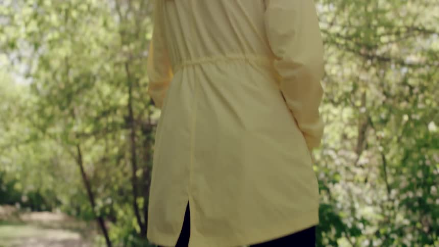 A woman is walking down a trail in the forest