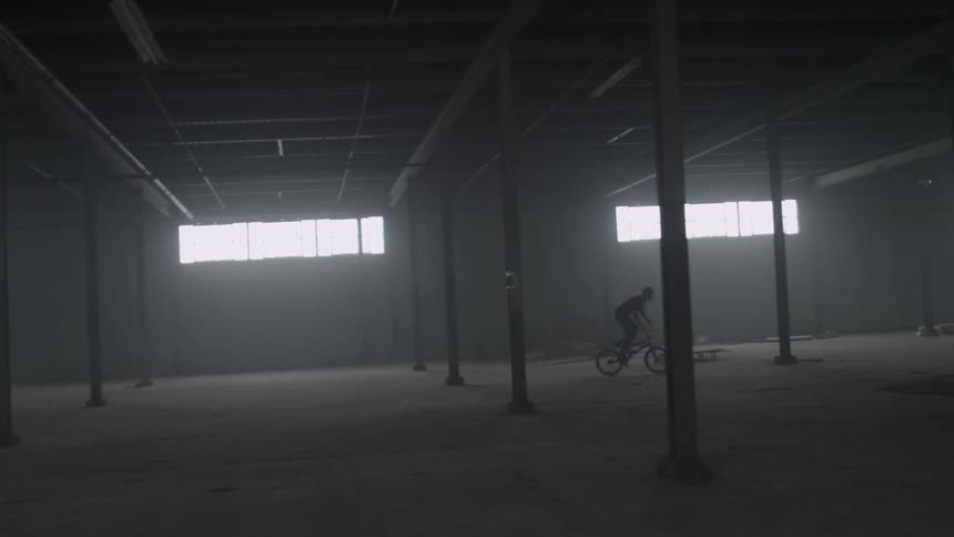 A person rides a bike through a warehouse
