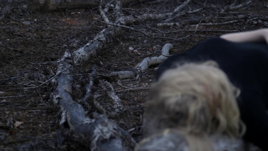 Woman sits up on a fallen tree