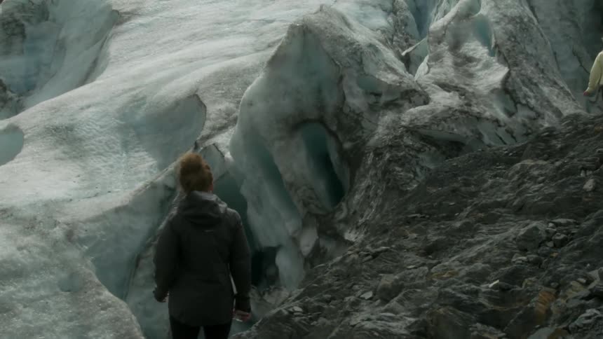 Friends are hiking at the edge of a glacier during the day