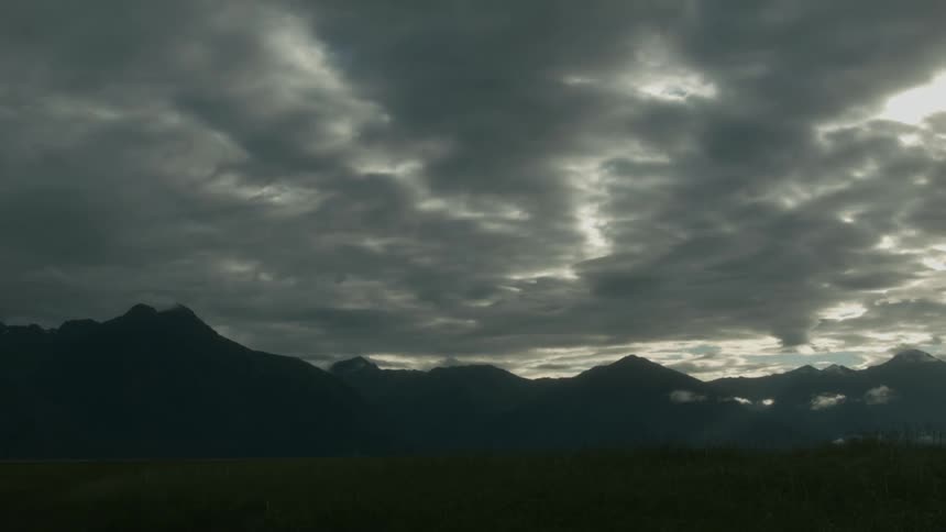 The mountains are covered in shade from the thick clouds