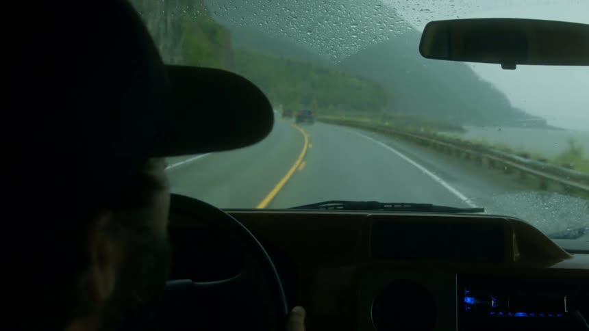 A person drives on a rainy road