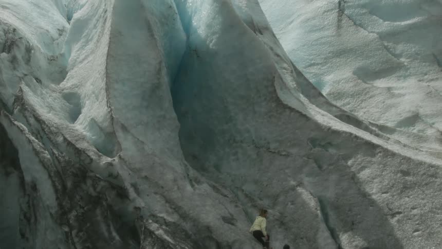 A man and woman climb an ice formation