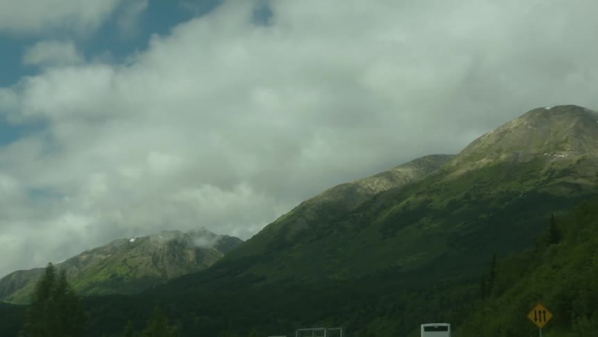 Clouds hang above a tall mountain