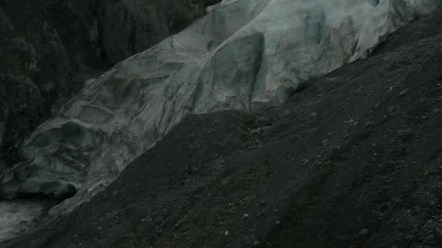 The ice on the mountain is melting down the rocks