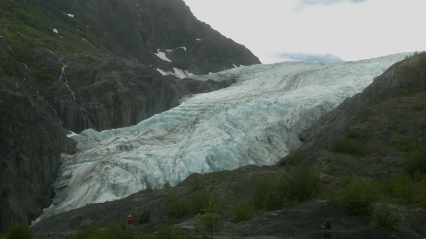 People walk toward a glacier