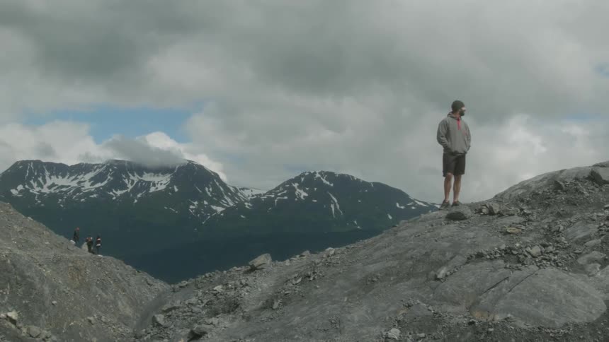 A man is standing on the side of a mountain