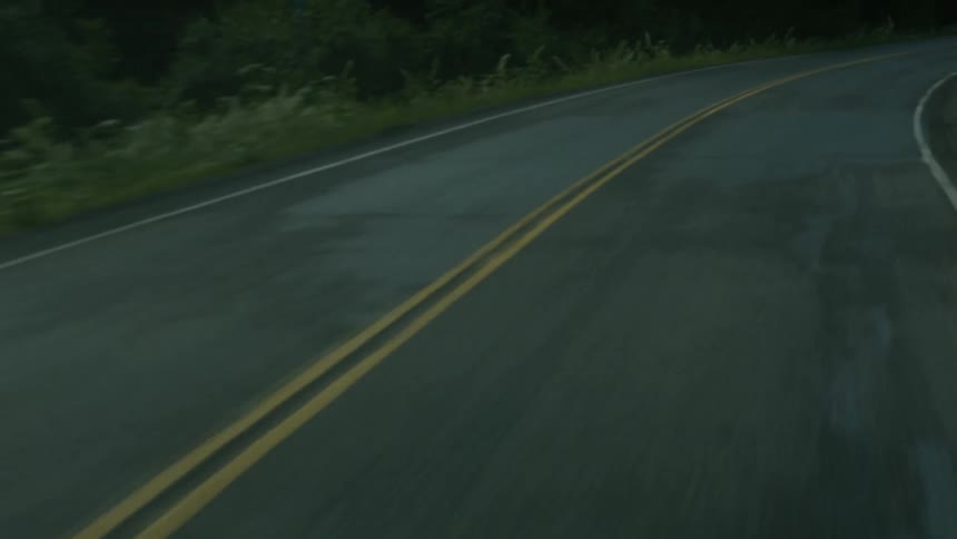 A car drives down a two lane highway