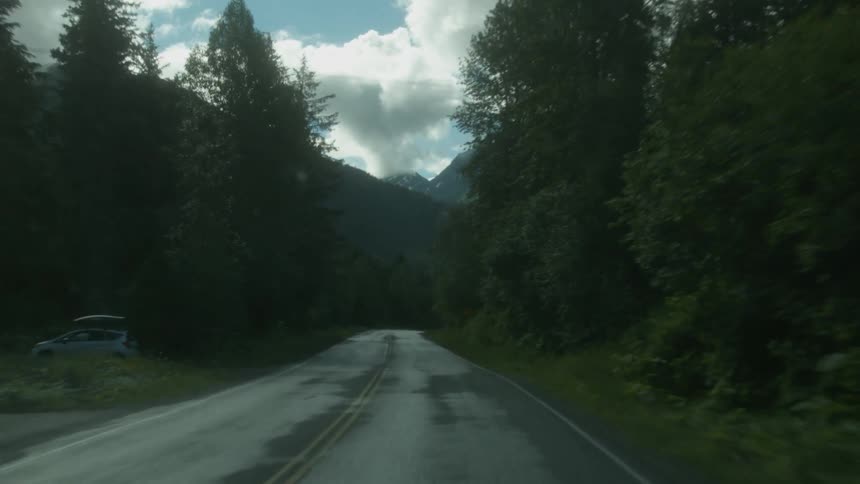 A vehicle travels down a mountain road
