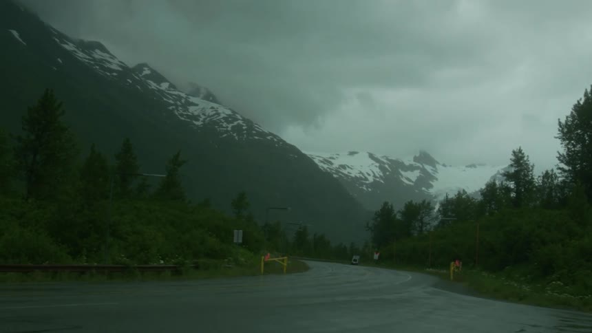A twisting road leading to snowy mountains