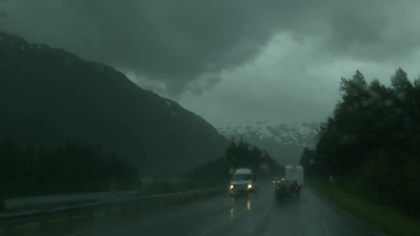 Cars drive on the road in the rain