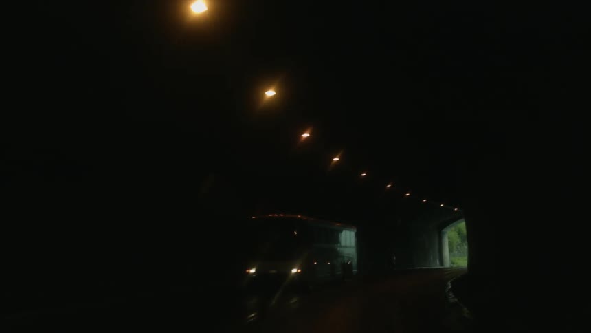 The tunnel is dark as cars pass through