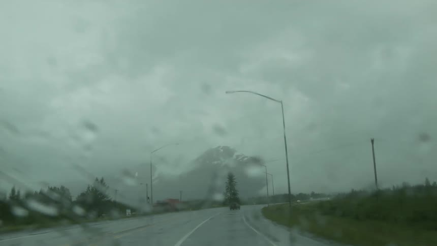 Windshield wipers going across a windshield on a rainy day