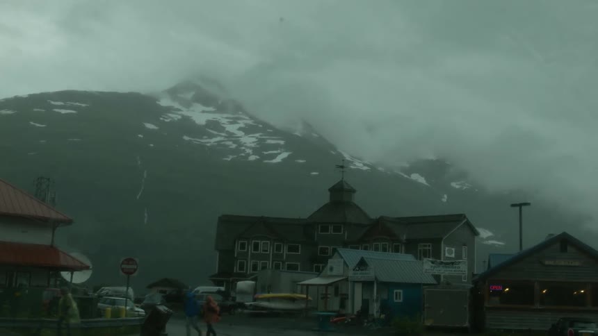 Car drives through town during rainstorm