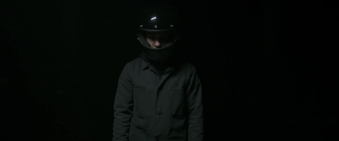 A man is wearing a black motorcycle helmet