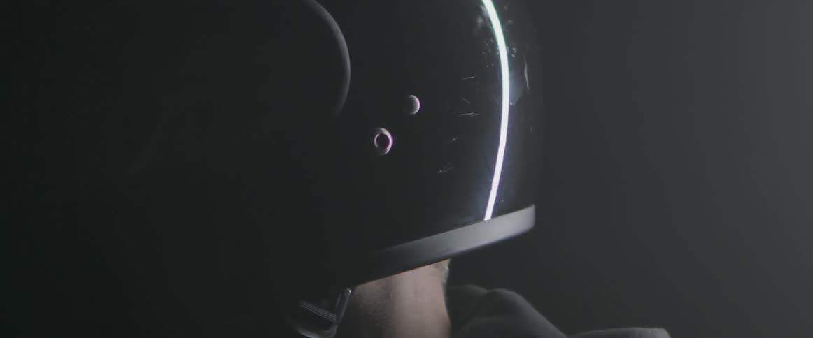 A man is wearing a black motorcycle helmet