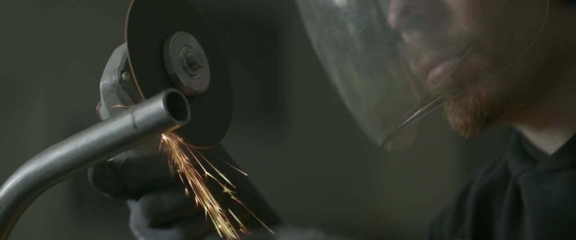 A man is using a circular saw to cut a pipe