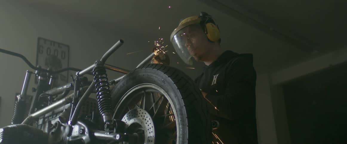 A man is welding pipes on his motorcycle