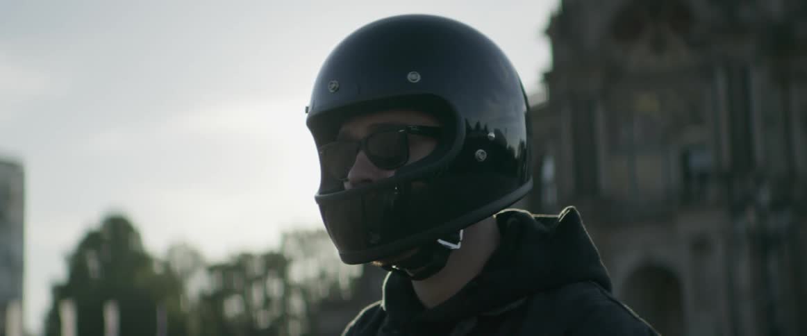 A person is wearing a black helmet and sunglasses