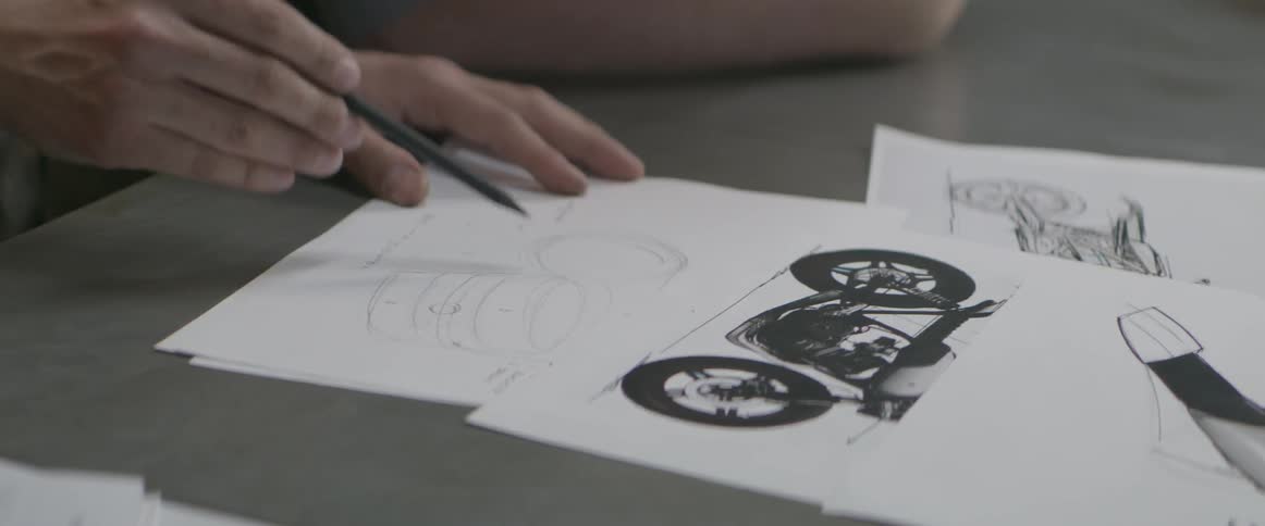 Man sketches motorcycles on paper