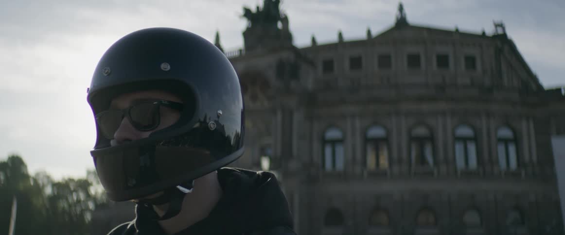 Man wearing a helmet in front of an old building