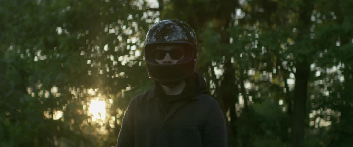 A man is wearing sunglasses and a motorcycle helmet
