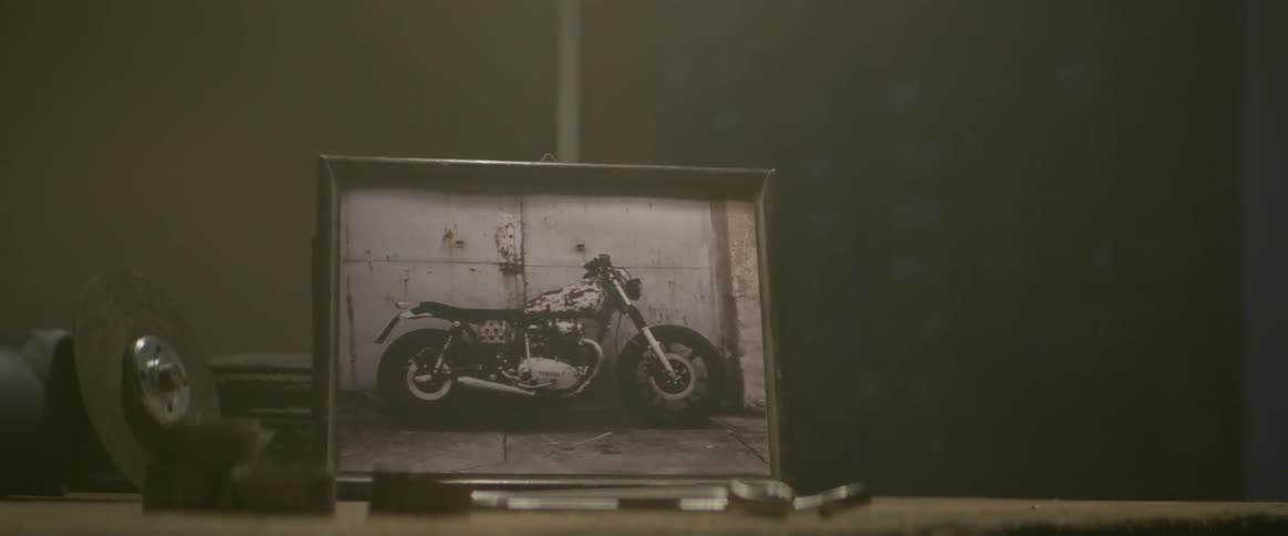 A photo of a motorcycle is sitting on a dresser