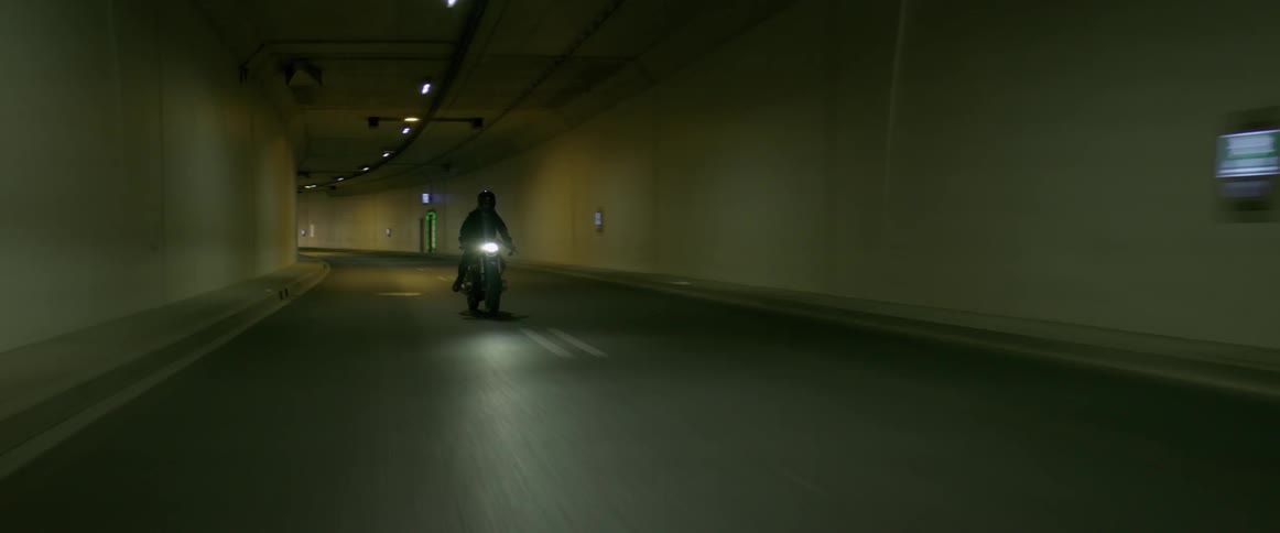 Motorcyclist riding through a highway tunnel